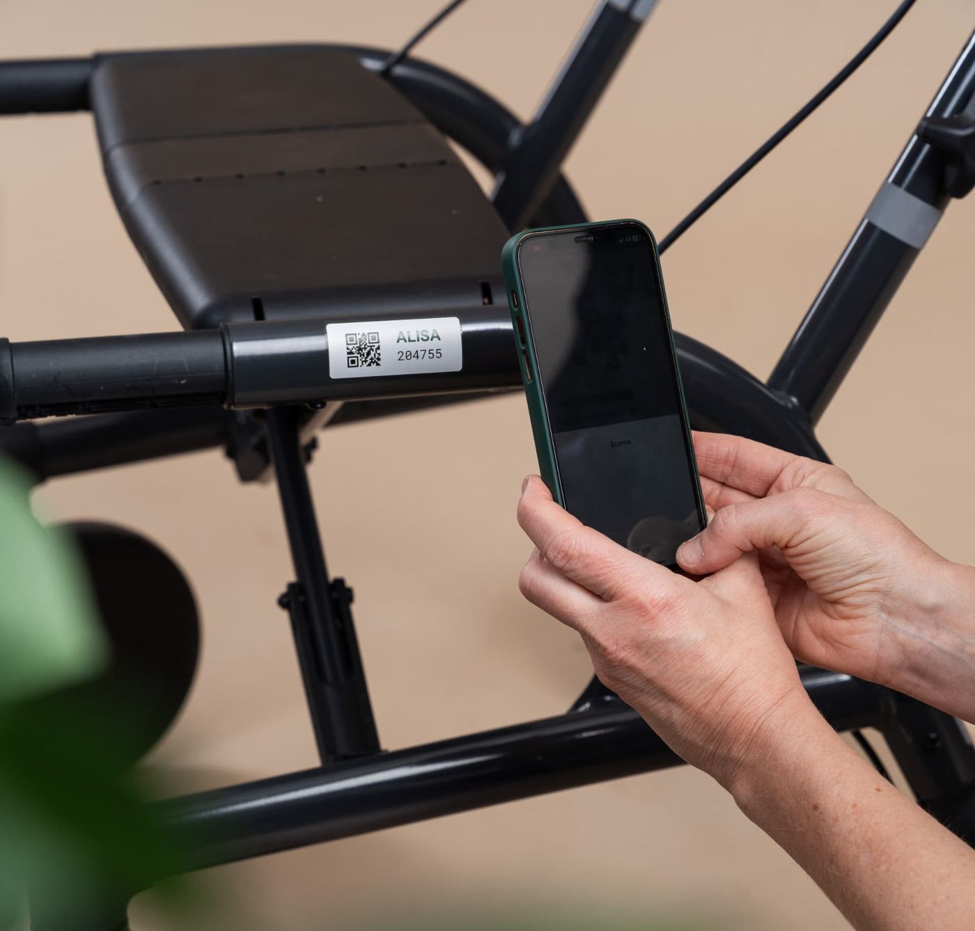 Medarbetare skannar QR-kod på en rollator med Alisa Med i mobilen